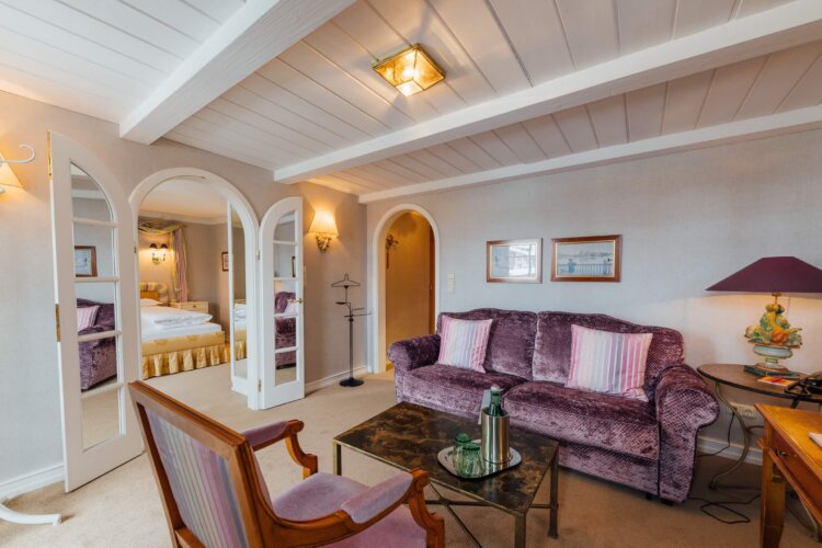 Gemütliches Zimmer im Hotel Edelweiss, Lech/Zürs am Arlberg, mit eleganter Einrichtung und Blick auf den Schlafbereich.