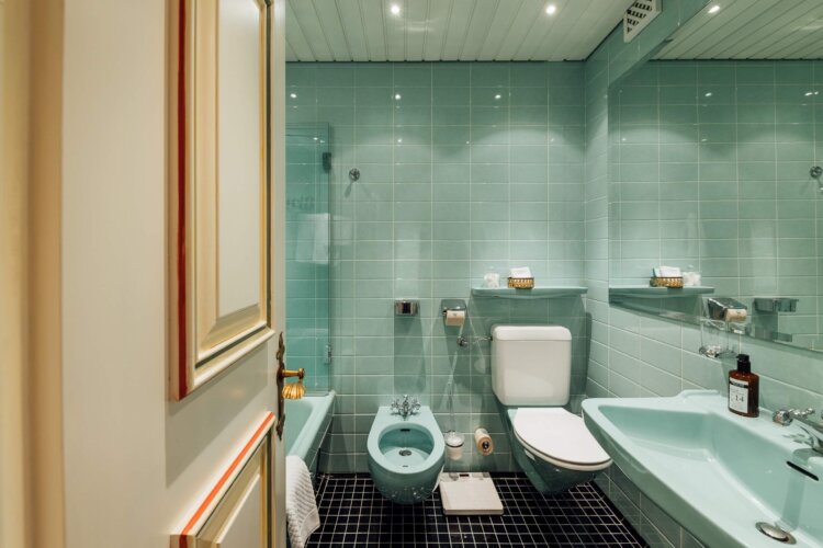 Modernes Badezimmer im Hotel Edelweiss mit turquoise Fliesen, eleganter Ausstattung und stilvollem Ambiente.