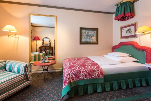 Gemütliches Hotelzimmer im Hotel Edelweiss mit eleganter Einrichtung, Bett, Sofa und stilvollen Accessoires.