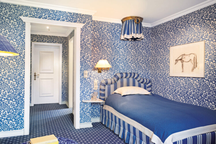 Helle, geschmackvoll eingerichtete Hotelzimmer im Hotel Edelweiss, Lech/Zürs, mit floralem blauem Design und gemütlicher Atmosphäre.