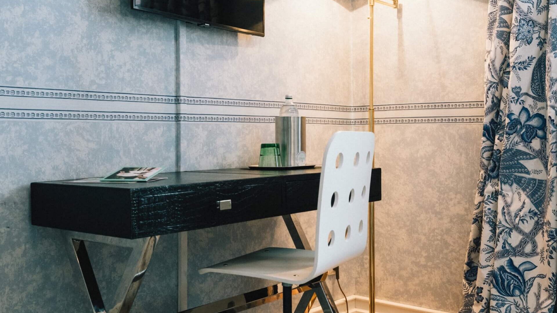 Stylisches Arbeits-Setup im Hotel Edelweiss mit Schreibtisch, Stuhl und TV in eleganter Atmosphäre.