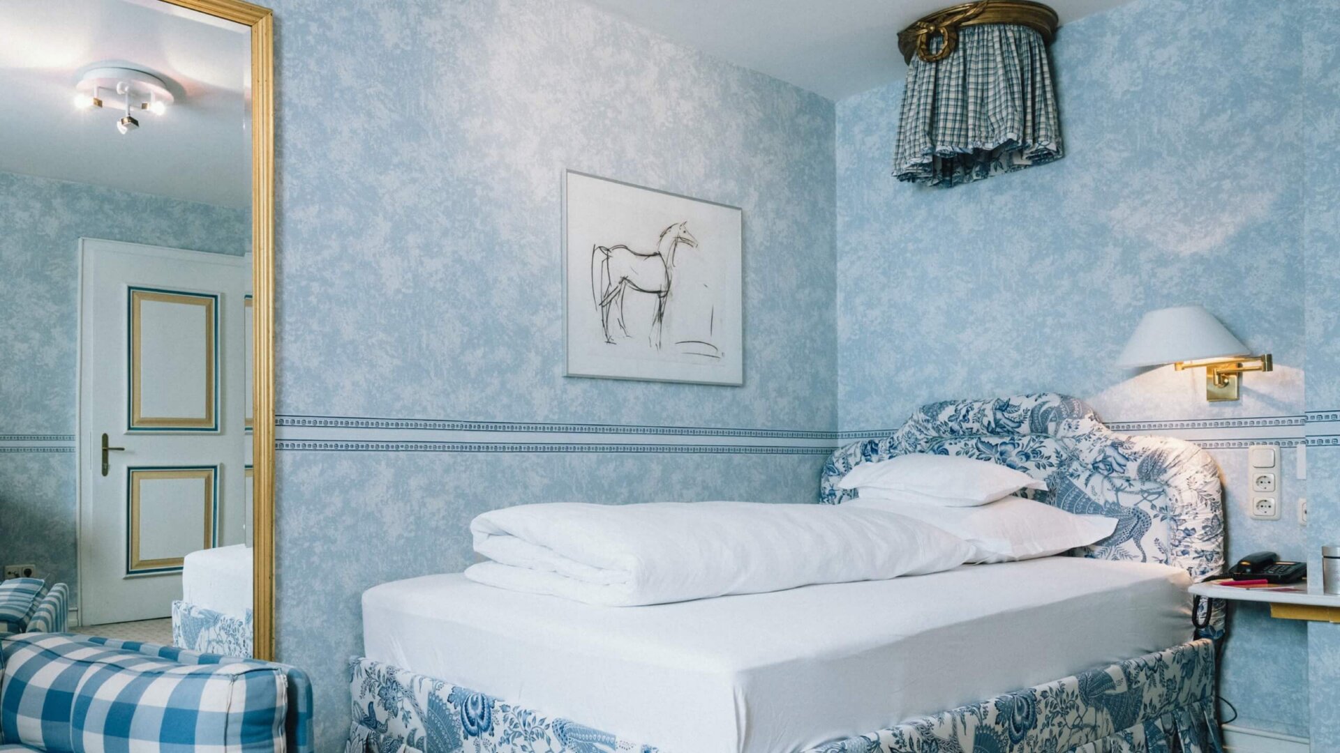 Gemütliches Hotelzimmer im Hotel Edelweiss, Lech/Zürs, mit elegantem Interieur in Blau und Weiß.