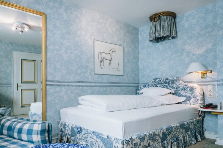 Gemütliches Hotelzimmer im Hotel Edelweiss, Lech/Zürs, mit elegantem Interieur in Blau und Weiß.