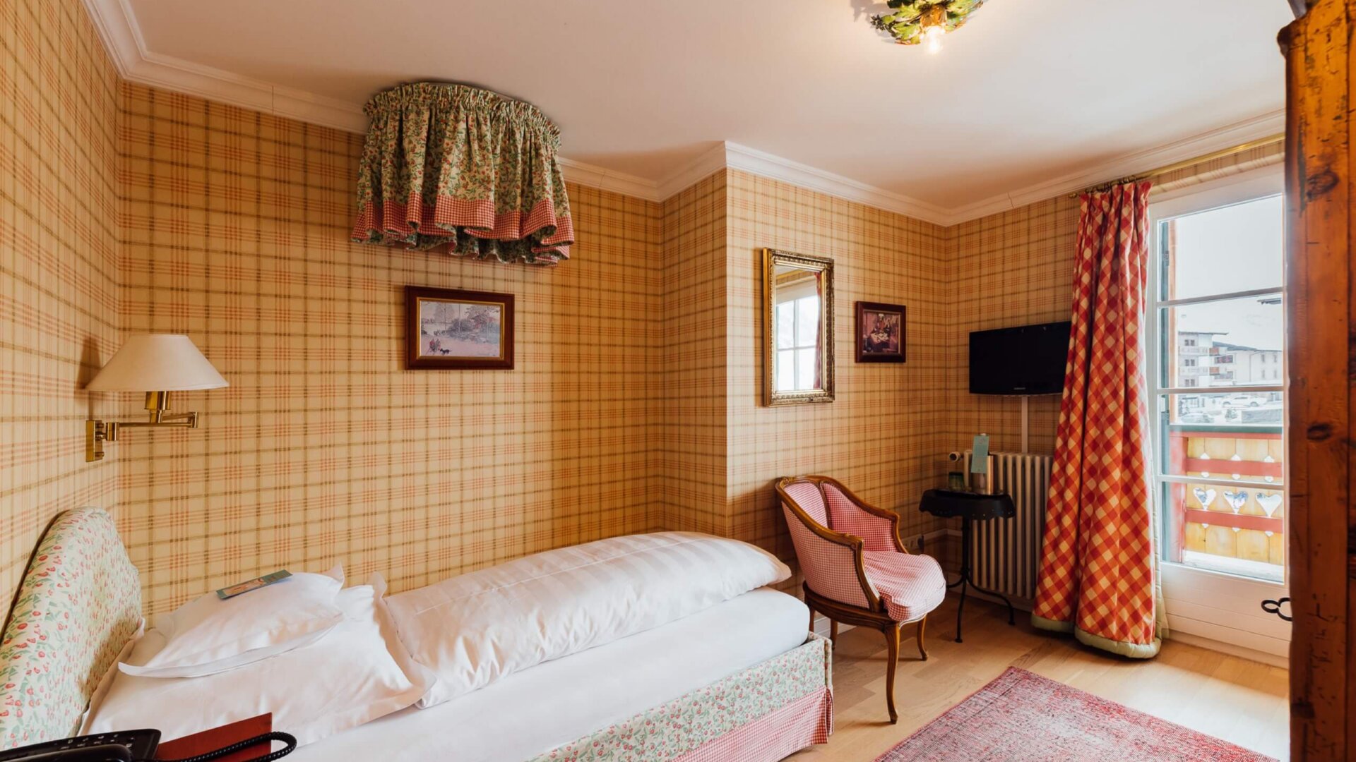 Gemütliches Hotelzimmer im Hotel Edelweiss in Lech/Zürs mit traditionellem Dekor und Balkonblick.