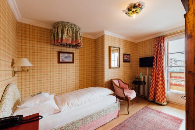 Gemütliches Hotelzimmer im Hotel Edelweiss in Lech/Zürs mit traditionellem Dekor und Balkonblick.