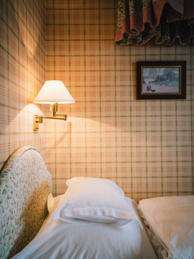 Gemütliches Schlafzimmer im Hotel Edelweiss, Lech/Zürs mit bequemen Kissen und sanfter Beleuchtung.