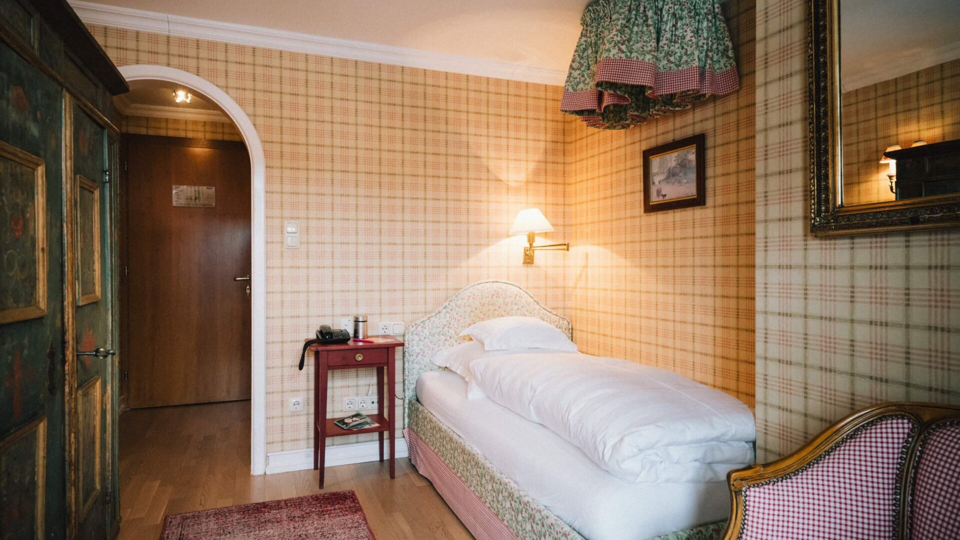 Gemütliches Einzelzimmer im Hotel Edelweiss in Lech/Zürs, freundlich gestaltet mit blumigen Akzenten und rustikalem Flair.