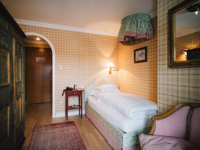 Gemütliches Einzelzimmer im Hotel Edelweiss in Lech/Zürs, freundlich gestaltet mit blumigen Akzenten und rustikalem Flair.