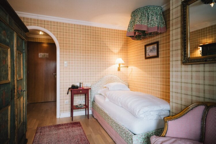 Gemütliches Einzelzimmer im Hotel Edelweiss in Lech/Zürs, freundlich gestaltet mit blumigen Akzenten und rustikalem Flair.