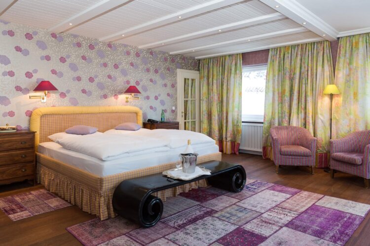 Gemütliches Hotelzimmer im Hotel Edelweiss in Lech/Zürs, elegant eingerichtet mit Blumenmustern und modernem Komfort.