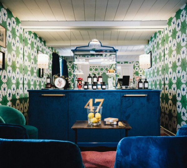 Stilvolle Hotelbar im Hotel Edelweiss, Lech/Zürs mit blauem Tresen und gemütlichem Ambiente. Ideal für entspannte Abende.