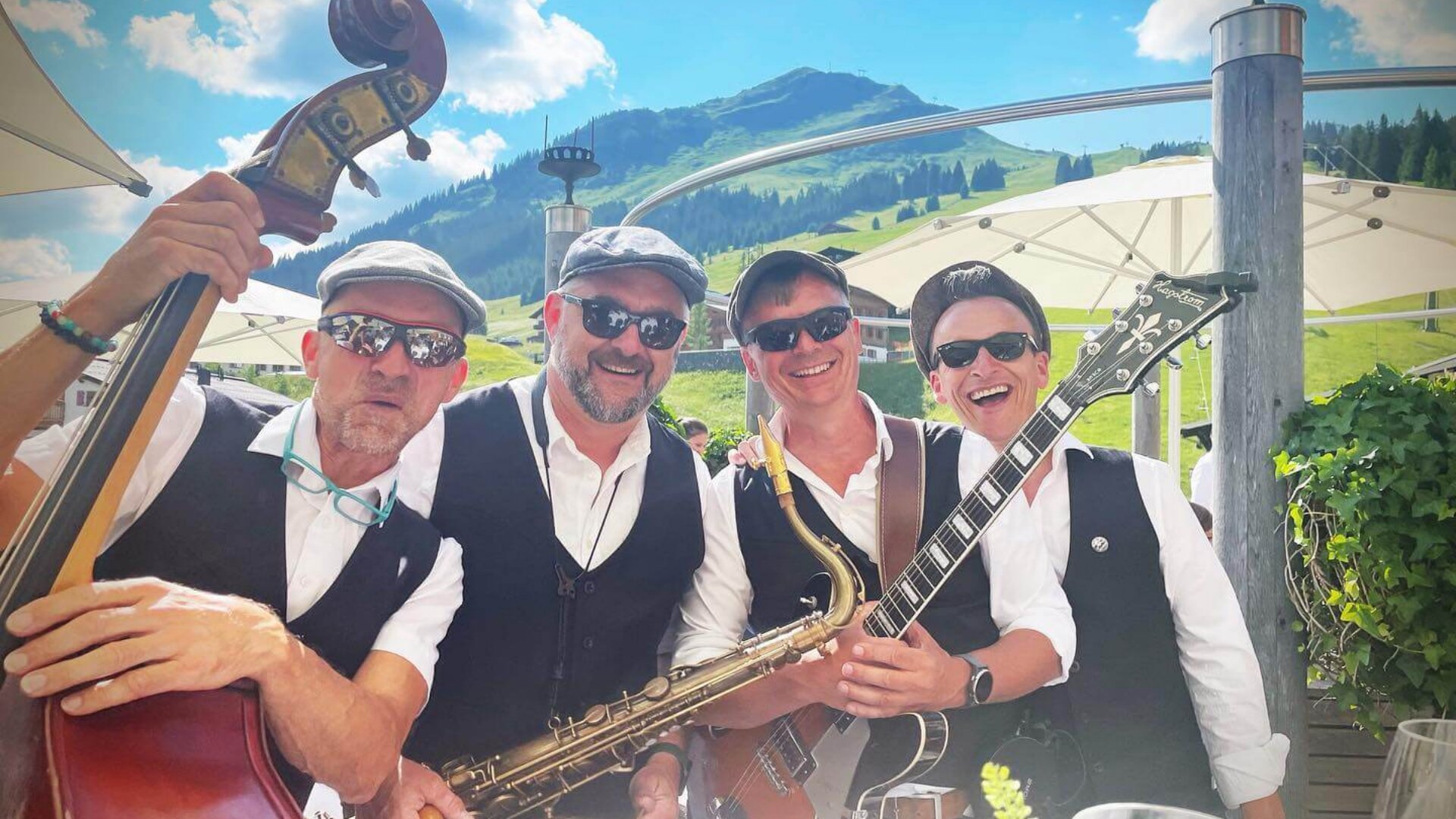 Musikanten in traditioneller Kleidung spielen Instrumente auf der Terrasse des Hotels Edelweiss in Lech/Zürs am Arlberg.